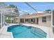 Screened-in pool area features a pristine pool, patio, and a neutral-toned home with large glass windows and doors at 5619 Oak Grove Ct, Sarasota, FL 34233