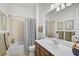 Bathroom featuring tub/shower combo, framed mirror and vanity with cherry wood cabinets at 5662 Fossano Dr, Sarasota, FL 34238