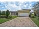Home exterior featuring brick driveway, two car garage, and well-manicured lawn at 5662 Fossano Dr, Sarasota, FL 34238