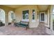 Inviting front porch with brick flooring and comfortable seating area at 5662 Fossano Dr, Sarasota, FL 34238