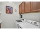 Bright Laundry Room features a washer, dryer, cabinets, and countertop workspace at 5662 Fossano Dr, Sarasota, FL 34238
