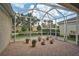 Screened-in patio featuring a brick floor, views of the manicured backyard, and natural light at 5662 Fossano Dr, Sarasota, FL 34238
