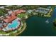 Beautiful aerial view of community with large pool, tennis courts, clubhouse, and lake with fountain feature at 5779 Wilena Pl, Sarasota, FL 34238