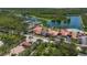 Aerial view of the community clubhouse, pools, tennis courts, and scenic lake at 5779 Wilena Pl, Sarasota, FL 34238