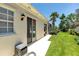 Rear exterior featuring sliding glass doors and manicured lawn; ideal for enjoying the outdoors at 5779 Wilena Pl, Sarasota, FL 34238