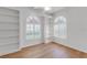 Bright bedroom features beautiful wood floors, built-in shelving, arched windows, and plantation shutters at 5779 Wilena Pl, Sarasota, FL 34238