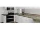Stylish kitchen showcasing white cabinetry, granite countertops, and modern appliances for a sleek cooking space at 5779 Wilena Pl, Sarasota, FL 34238