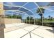 Large screened-in patio featuring plenty of space for seating and entertaining with views of backyard and palm trees at 5779 Wilena Pl, Sarasota, FL 34238