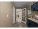 Hallway view to laundry room featuring navy cabinets and a utility sink at 616 59Th Nw St, Bradenton, FL 34209