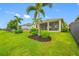 This grassy backyard boasts pretty landscaping, a screened-in lanai, and a great lake view at 6550 Devesta Loop, Palmetto, FL 34221