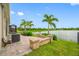 This backyard features a lovely lake view, a brick patio and block sitting wall, as well as pretty palm trees at 6550 Devesta Loop, Palmetto, FL 34221