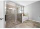 Modern bathroom featuring a glass-enclosed shower, soaking tub, and neutral tile flooring for a serene spa-like retreat at 6550 Devesta Loop, Palmetto, FL 34221