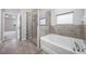 Bright bathroom features a glass shower, soaking tub and tiled floor at 6550 Devesta Loop, Palmetto, FL 34221