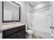 Cozy bathroom with a shower-tub combo, dark cabinets, and a framed mirror at 6550 Devesta Loop, Palmetto, FL 34221