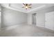 A Primary bedroom features neutral walls, a tray ceiling, and plush carpeting for ultimate comfort and style at 6550 Devesta Loop, Palmetto, FL 34221