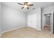 A carpeted bedroom with a ceiling fan and a double-door closet, painted in neutral colors at 6550 Devesta Loop, Palmetto, FL 34221