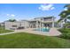 Luxurious backyard featuring a modern fireplace, lounge seating, and lush landscaping at 676 Regatta Way, Bradenton, FL 34208
