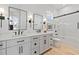 Bright bathroom featuring double sinks, white cabinetry, and a glass shower door at 676 Regatta Way, Bradenton, FL 34208