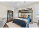 Comfortable bedroom with hardwood floors, bunk beds, a gray couch, and a wood bookshelf at 676 Regatta Way, Bradenton, FL 34208