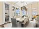 Bright dining room featuring modern chandelier and views of the outdoor pool at 676 Regatta Way, Bradenton, FL 34208