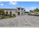 Luxury home featuring a paver driveway, a three-car garage, and professionally landscaped grounds at 676 Regatta Way, Bradenton, FL 34208