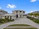 Stunning two-story home featuring a spacious driveway, meticulously landscaped yard, and elegant architectural details at 676 Regatta Way, Bradenton, FL 34208
