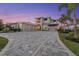 Stately residence featuring an expansive paver driveway, a three-car garage, and elegant architectural details at 676 Regatta Way, Bradenton, FL 34208