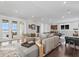 Spacious living area featuring comfortable gray sofas, hardwood floors, and a pool table in the background at 676 Regatta Way, Bradenton, FL 34208