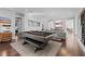 Spacious game room with a dark wood pool table, hardwood floors, and comfortable gray couches at 676 Regatta Way, Bradenton, FL 34208