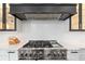 Gourmet kitchen featuring a professional-grade range and custom range hood at 676 Regatta Way, Bradenton, FL 34208