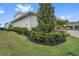 Side view of the house surrounded by manicured landscaping and lush greenery at 676 Regatta Way, Bradenton, FL 34208