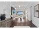 Expansive living area with high ceilings, wood floors, a modern fireplace, and water views at 676 Regatta Way, Bradenton, FL 34208