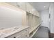 Organized mudroom area featuring ample storage, hooks, and a marble countertop at 676 Regatta Way, Bradenton, FL 34208