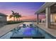 Stunning waterfront view with a pool and hot tub overlooking beautiful sunset and ocean at 676 Regatta Way, Bradenton, FL 34208