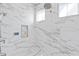 Detailed view of the marble tile shower with modern shower head and built-in shelf at 676 Regatta Way, Bradenton, FL 34208