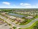 Beautiful aerial view of a lakeside home in a well-manicured community with a paver driveway and lush landscaping at 7661 Summerland Cv, Bradenton, FL 34202