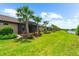 Picturesque backyard featuring manicured lawns, mature palm trees and scenic pond views, creating a serene outdoor oasis at 7661 Summerland Cv, Bradenton, FL 34202