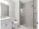 Modern bathroom featuring dual vanity sinks and a frameless shower at 7661 Summerland Cv, Bradenton, FL 34202