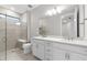 Bright bathroom featuring double vanity, frameless glass shower, and tile flooring at 7661 Summerland Cv, Bradenton, FL 34202