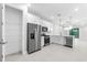 Bright, open kitchen with stainless steel appliances, pantry, white cabinets, and tile flooring at 7661 Summerland Cv, Bradenton, FL 34202