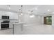 Open concept kitchen and living room with modern lighting and access to the outdoors at 7661 Summerland Cv, Bradenton, FL 34202