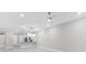Open living space with recessed lighting, modern light fixtures, and kitchen in background at 7661 Summerland Cv, Bradenton, FL 34202