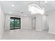Open living area with sliding glass doors, recessed lighting, and elegant chandelier at 7661 Summerland Cv, Bradenton, FL 34202