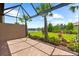 Screened patio showcases a brick floor, offering relaxing views of the meticulously landscaped lawn and a peaceful pond at 7661 Summerland Cv, Bradenton, FL 34202