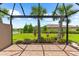 Screened patio displays brick flooring and scenic views of the lush lawn, colorful flowers and a serene pond at 7661 Summerland Cv, Bradenton, FL 34202