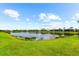 Scenic pond surrounded by lush green lawns and well-maintained landscaping, offering tranquil waterfront views and community charm at 7661 Summerland Cv, Bradenton, FL 34202