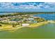 Stunning aerial view of the community with lake, clubhouse, pool, tennis courts, and lush landscaping at 7781 Grande Shores Dr, Sarasota, FL 34240