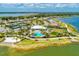 Aerial view of a community clubhouse with a pool, tennis courts, lake access and beautiful landscaping at 7781 Grande Shores Dr, Sarasota, FL 34240