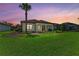 Expansive backyard with lush green grass and professionally landscaped garden beds and distant screened lanai at 7781 Grande Shores Dr, Sarasota, FL 34240