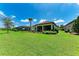 Expansive backyard with lush green grass, mature landscaping, screened lanai, and room for recreation at 7781 Grande Shores Dr, Sarasota, FL 34240